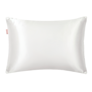 White satin pillow with a small pink tag on the left edge, close-up view of the fabric's sheen.