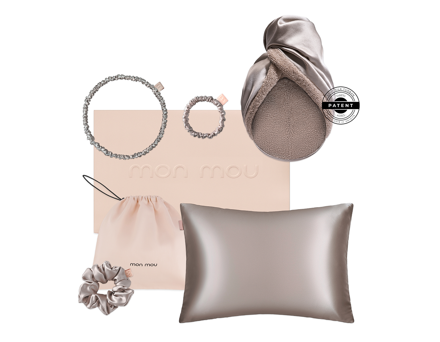 Flat lay of blush-pink fashion set: satin pillow, drawstring pouch, two textured rings and a scrunchie with a metallic box logo in soft tones.