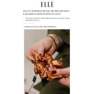 Close-up of hands tying a bronze satin scrunchie around a bundle of ribbons or fabric.