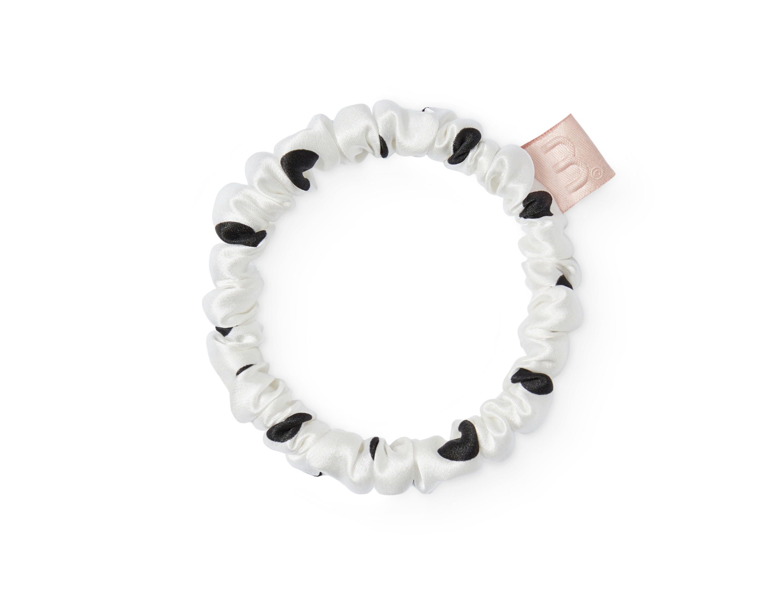White satin scrunchie with black leopard spots, laid in a loose circle on a white background (close-up).