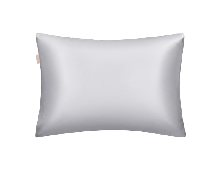 Light gray satin pillow with a small pink tag on the left edge.