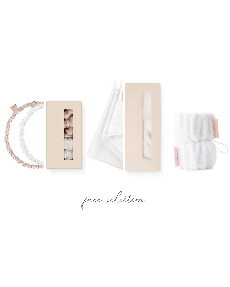 Flat lay of pale pink cosmetic boxes, white fabric bags, hair ties, and a fluffy white towel along the bottom edge on a white background (text 'face selection' at bottom).