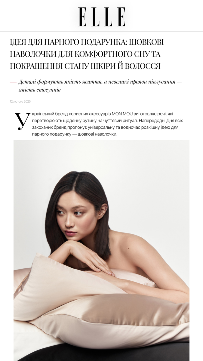 Model reclining with beige satin pillows in a minimalist studio setting for a fashion article