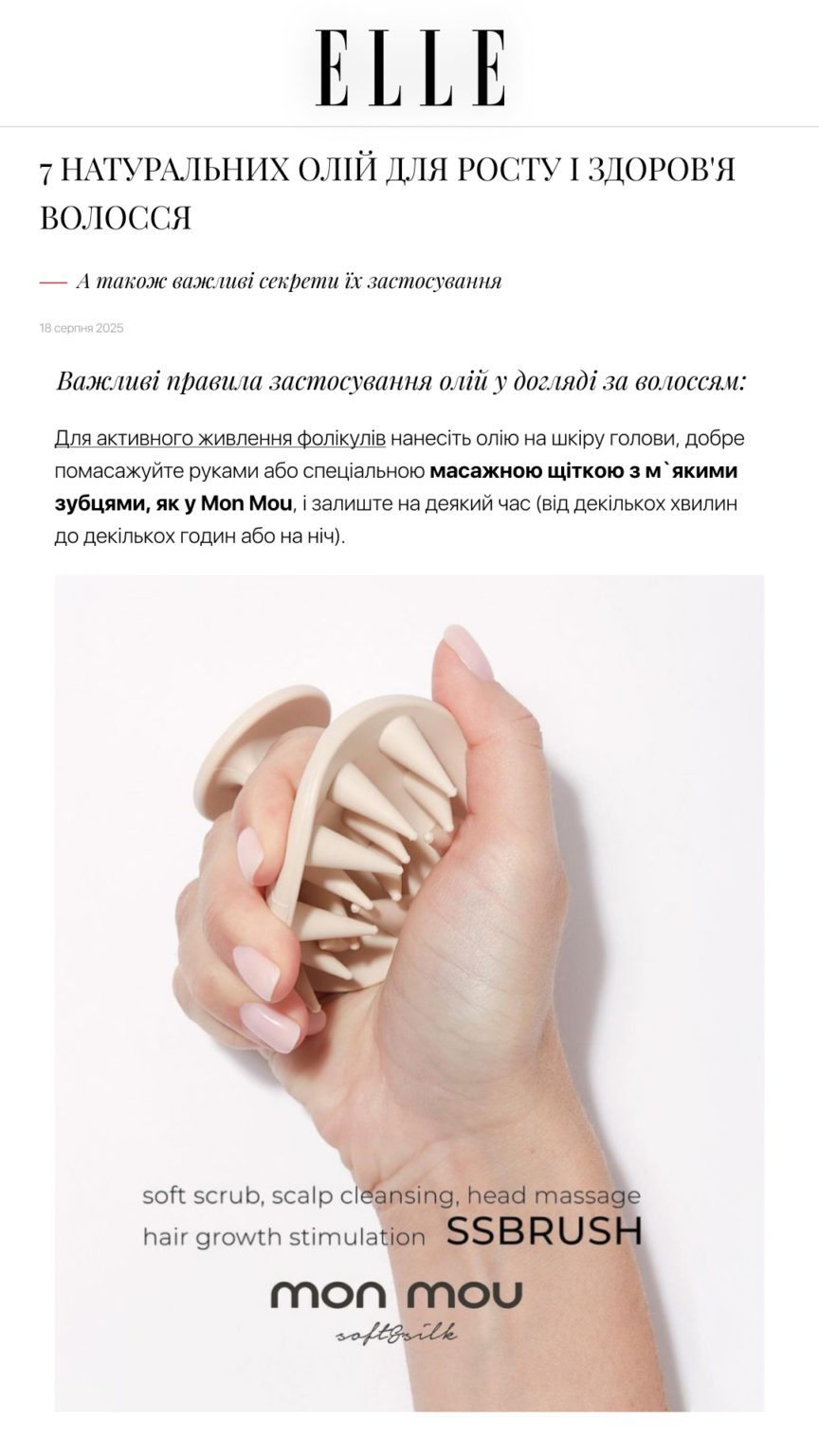 Hand holding a beige silicone scalp massager with pointy bristles for scalp massage