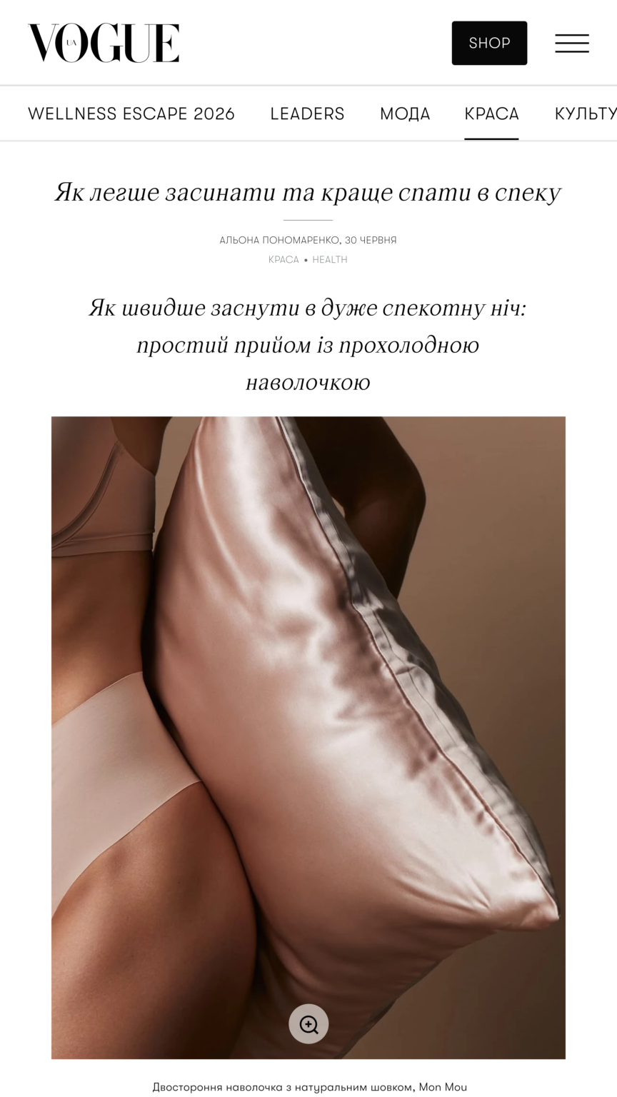 Close-up of a person in champagne-colored satin lingerie against a warm background, showcasing smooth fabric and skin tone.|